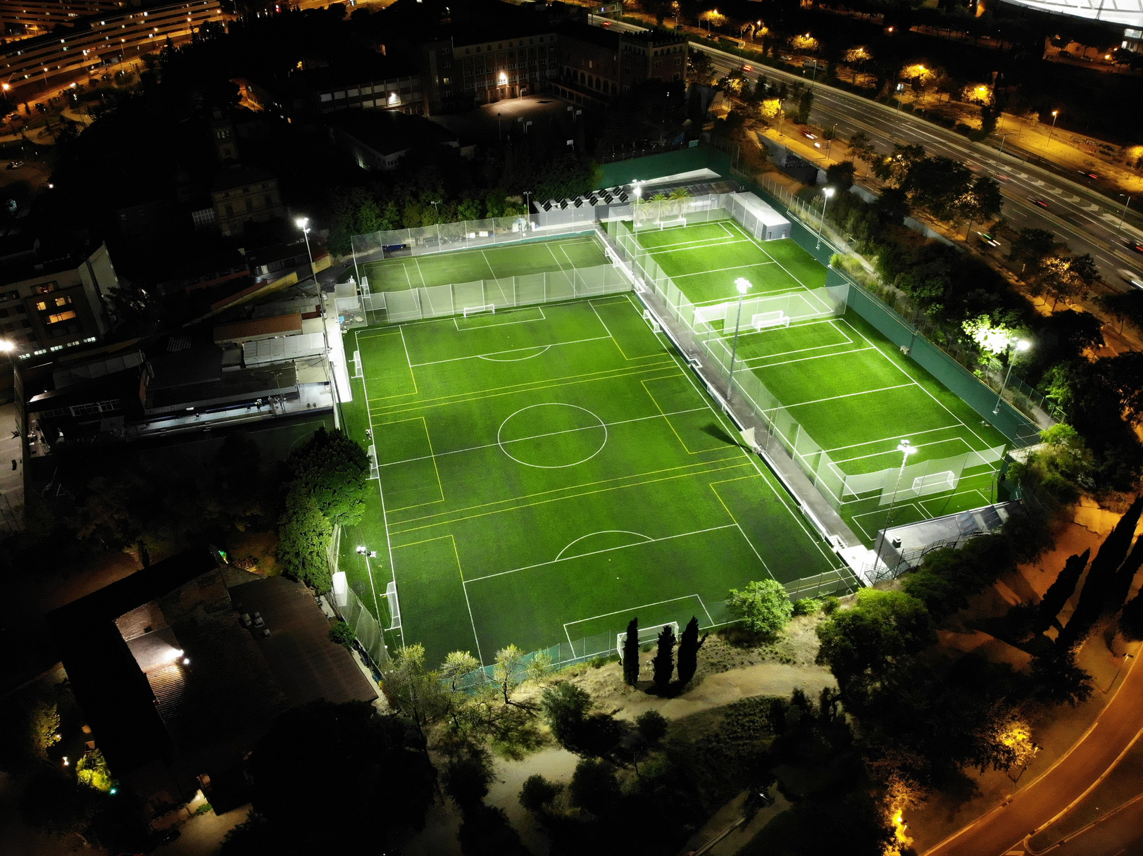 Vista aérea nocturna de los campos de fútbol iluminados en Barcelona